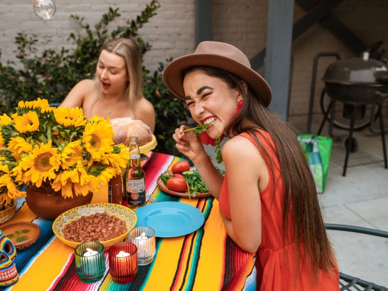 woman in red sleeveless dress sitting on chair eating