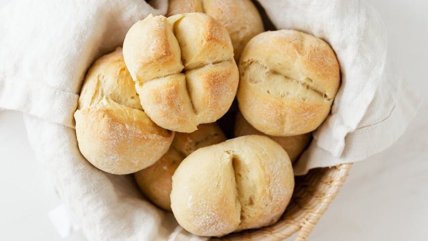 basket with fresh swiss buns on marble table