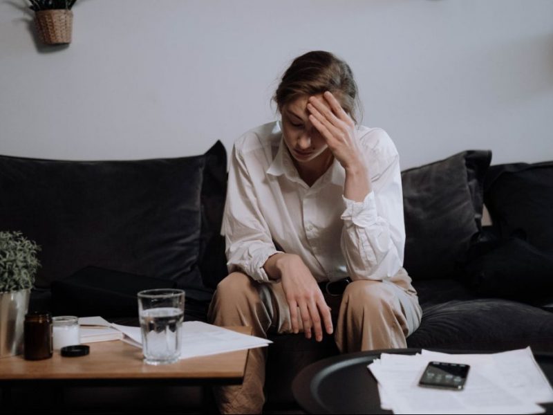 a woman with problems sitting on the sofa