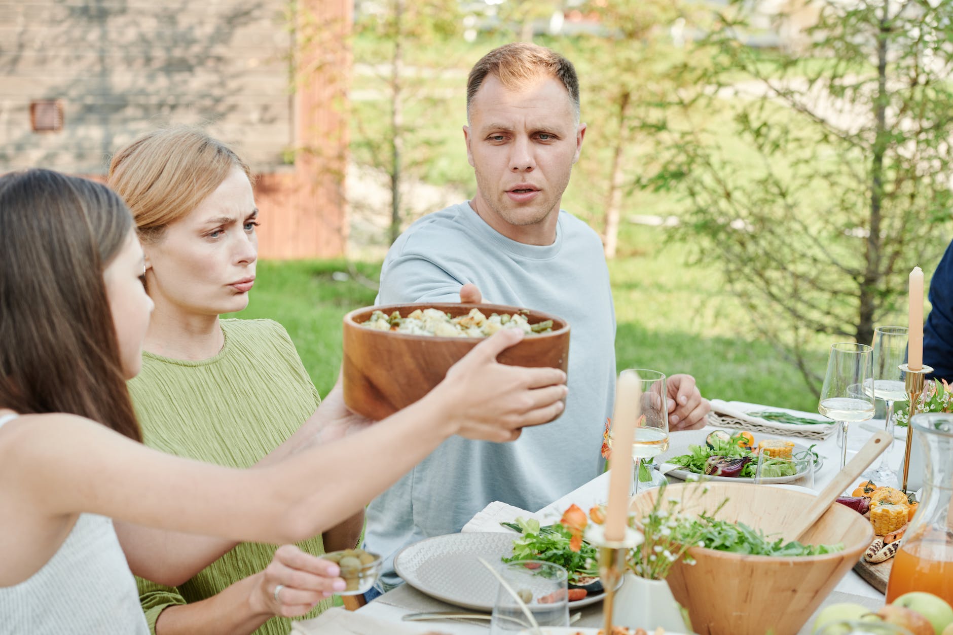 kid passing a bowl of salad