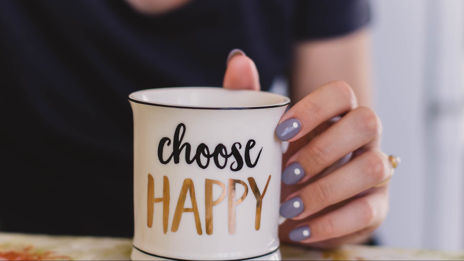 selective focus photography of person touch the white ceramic mug with choose happy graphic